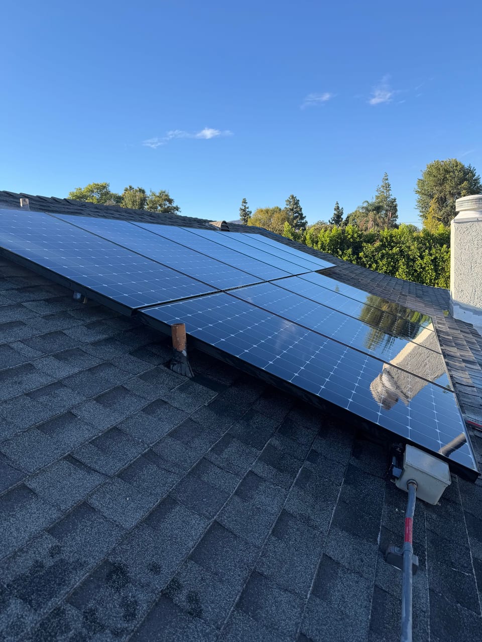 Clean rooftop solar panels on an asphalt shingle roof in Granada Hills, Los Angeles, after professional cleaning